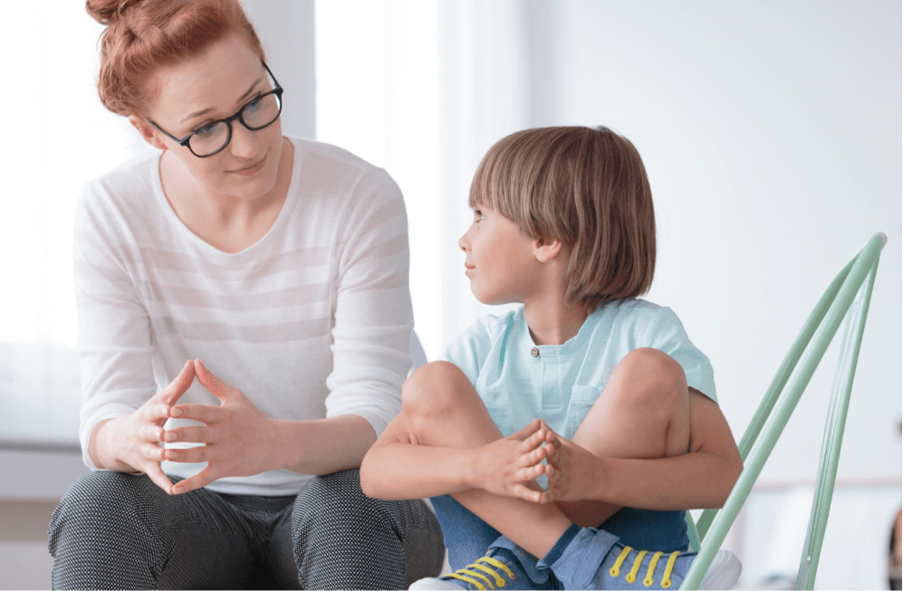 A coach in a friendly one-to-one session with a young boy, talking at eye level