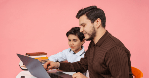 An older sibling helping a young boy study together at a laptop