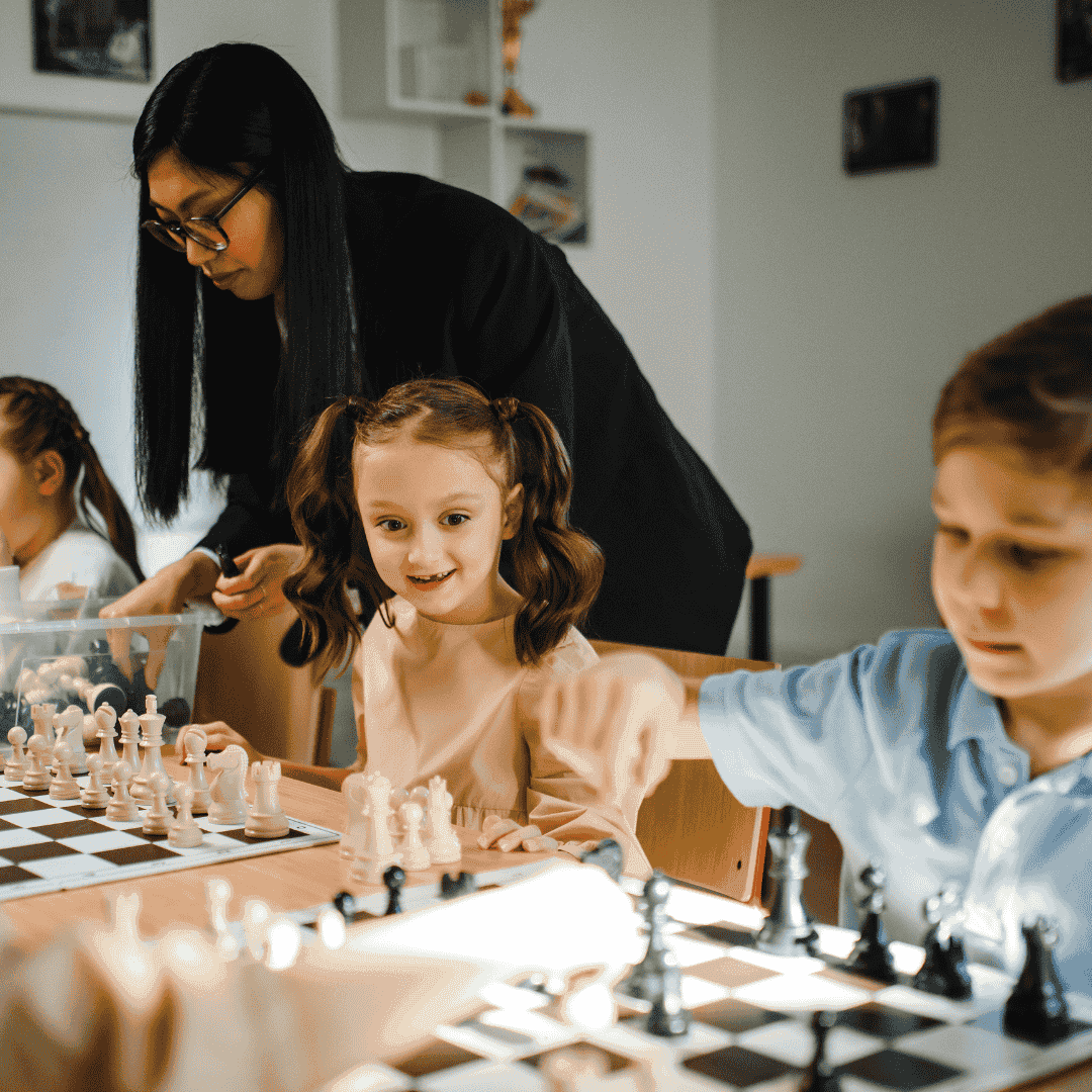 A chess coach guiding young children through practice games in a chess class